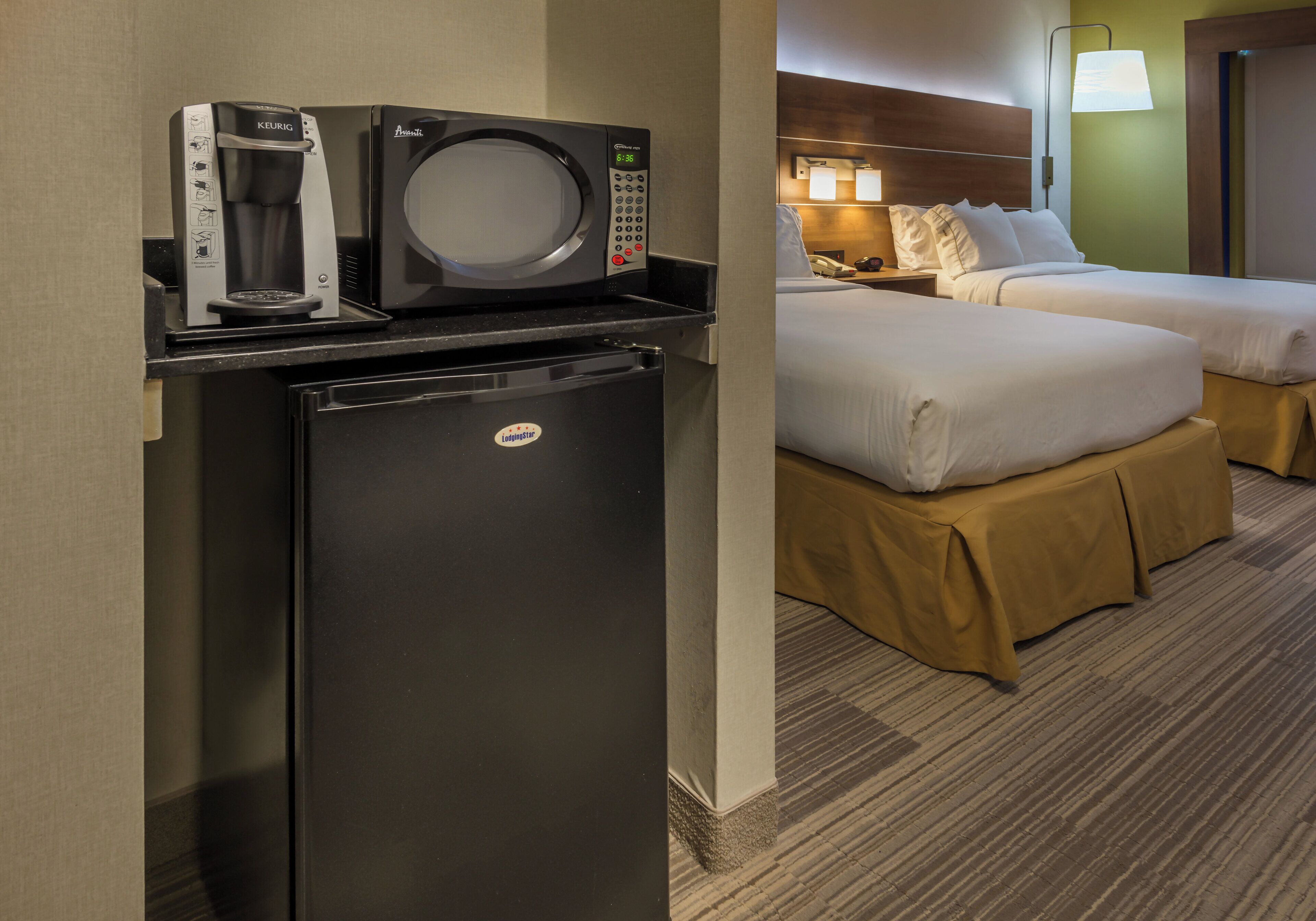 A compact kitchenette with a coffee maker, microwave, and refrigerator.