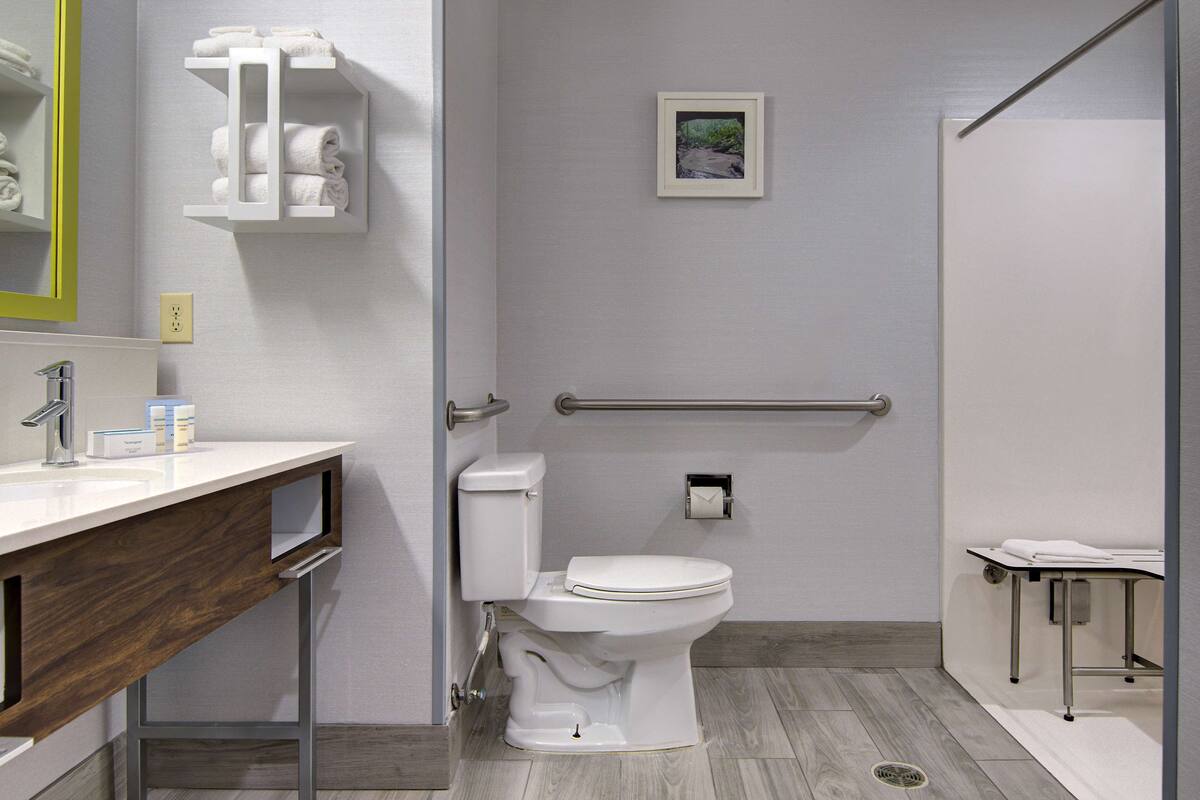 A modern bathroom with a white sink, toilet, and vanity.