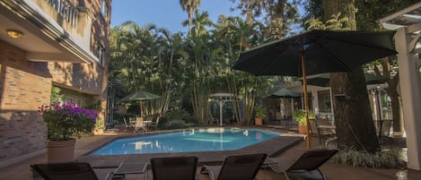 Una piscina al aire libre, sombrillas