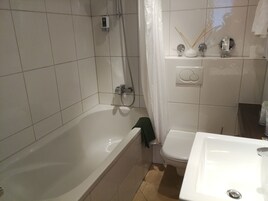Un baño con bañera, inodoro y lavamanos.