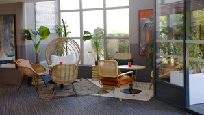 Un interior moderno con muebles de mimbre, ventanas amplias y plantas de interior.