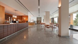 A spacious lobby with a long reception desk, seating area, and large windows. - Exe Via Argentum (Silleda)
