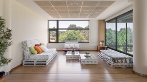 A spacious room with a large window, a sofa, a coffee table, and a bed. - Exe Via Argentum (Silleda)