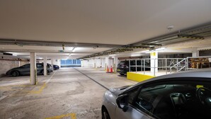 Un aparcamiento subterráneo de varios niveles con varios coches estacionados.