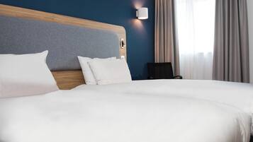 A neatly made bed with white linens in a hotel room.