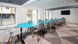 A conference room with a long table and chairs, large windows, and a flat-screen TV on the wall. - Holiday Inn Express Swindon City Centre by IHG (Swindon)