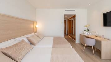 Una habitación de hotel con cama, escritorio, silla y televisor.