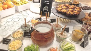 A buffet with various food items including fruits, nuts, and desserts.
