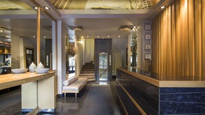 A modern hotel lobby with a reception desk, seating area, and a staircase leading to other floors. - Taxim Suites Residences Istanbul (Istanbul)