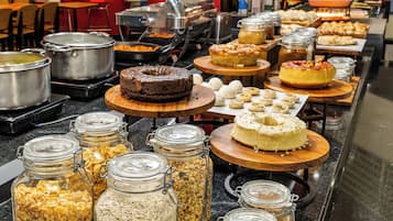 Um buffet com diversos alimentos e utensílios de cozinha.