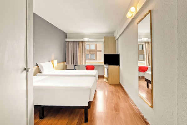 A hotel room with a bed, bedside table, TV, and a large mirror. - Slim Hotel Campinas (Campinas)
