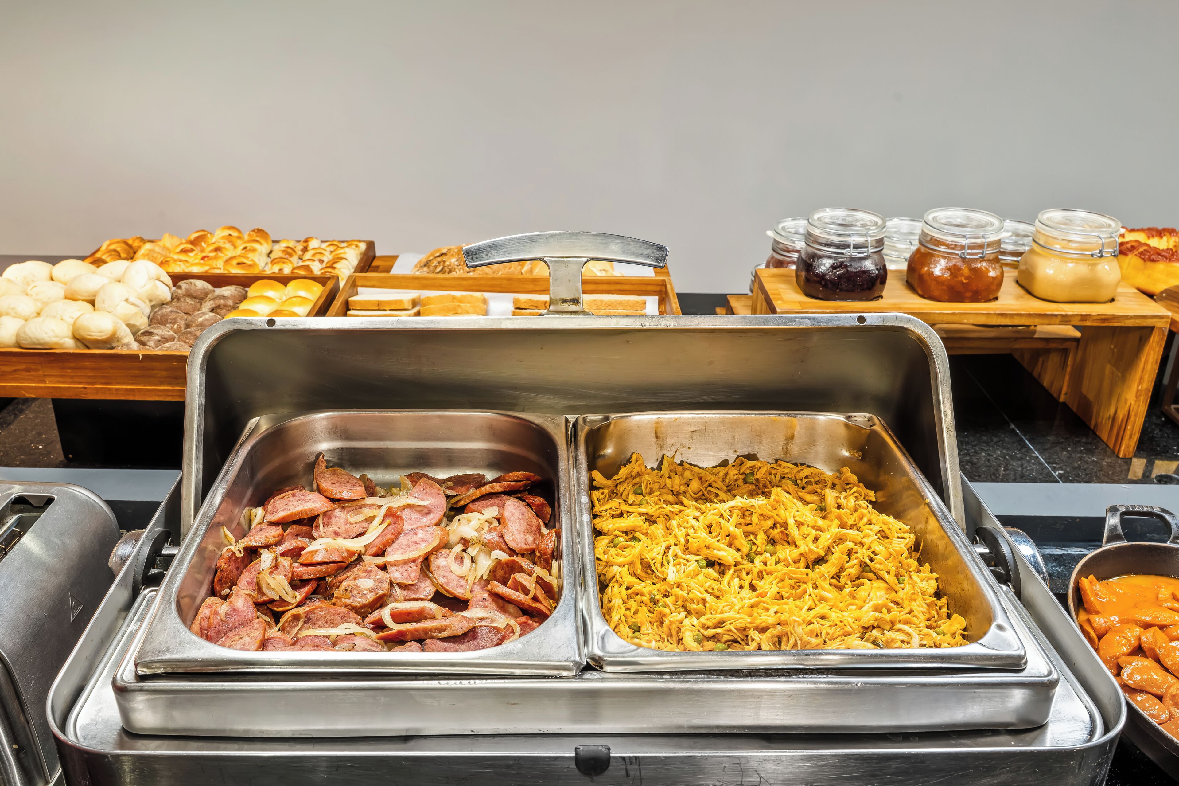 Buffet variado com carnes, queijos e doces.