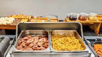 Buffet variado com carnes, queijos e doces.