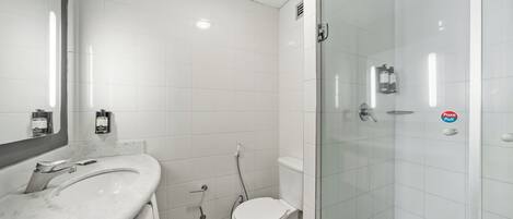 A bathroom with a sink, toilet, and glass-enclosed shower.