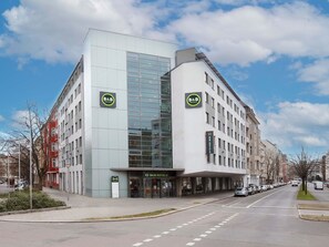 Un hôtel de type « bed and breakfast » moderne, doté d’une façade en verre, de plusieurs étages et d’une entrée imposante.