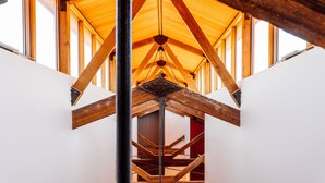 Een houten interieur met een hoge plafond en zichtbare balken.