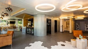 Un moderno vestíbulo con suelo de diseño hexagonal, una zona de recepción con mostrador y arreglos de asientos.