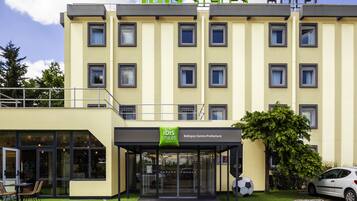A hotel with a modern design, featuring a prominent "ibis Styles Hotel" sign, a Bobigny Centre Prefecture label, and a visible parking area.