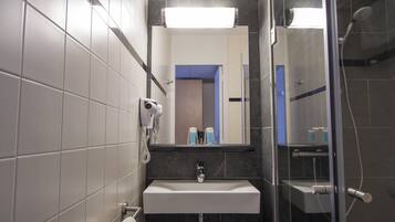 Ein modernes Badezimmer mit Waschbecken, Spiegel und Dusche.