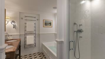 A bathroom with a double sink vanity, a bathtub, and a shower area.