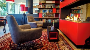 Ein moderner Loungebereich mit Kamin, Bücherregal und bequemen Sitzgelegenheiten.