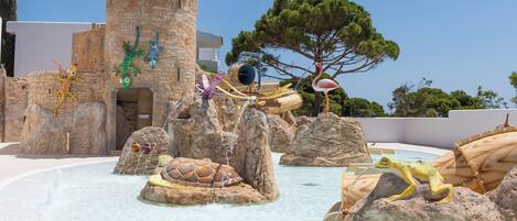 A water park with rock formations, a castle-like structure, and various animal sculptures.