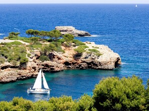 A coastal landscape with rocky terrain and clear blue waters. - Inturotel Esmeralda Park (Santanyi)