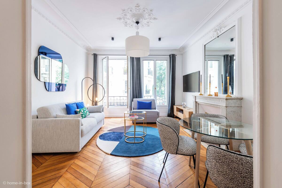 Ein modernes Wohnzimmer mit einer Couch, einem Glastisch und einem Kamin.