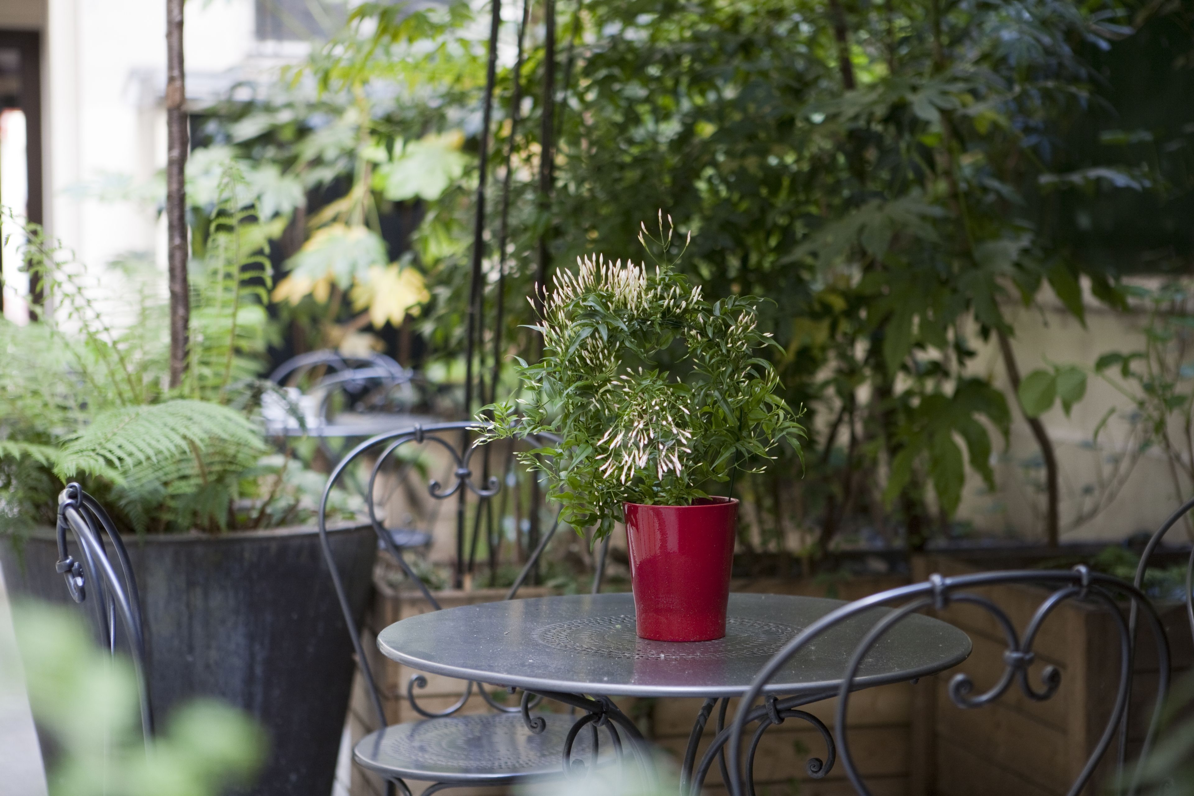 A round metal table with a red pot containing a plant.