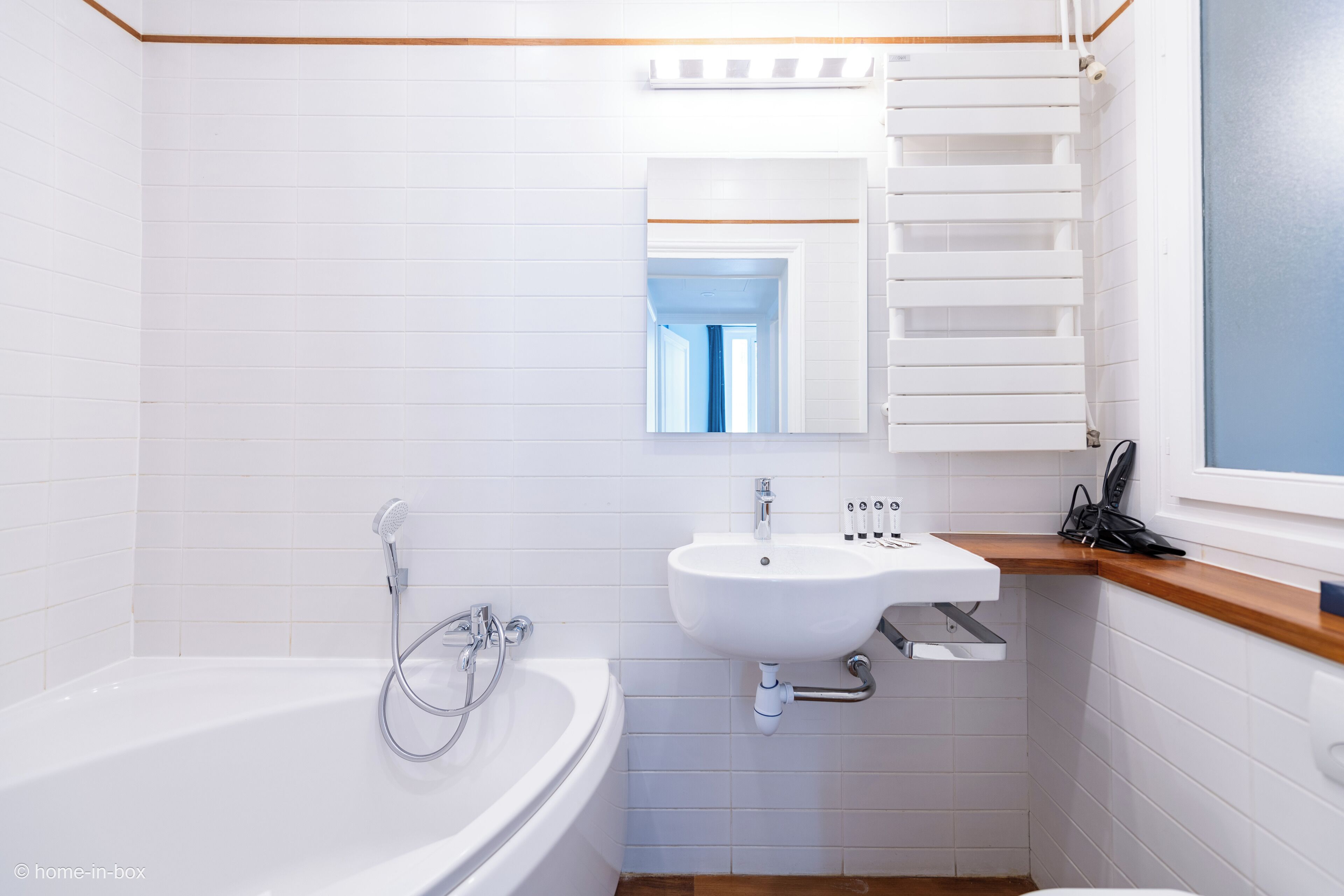 Une salle de bain avec une baignoire blanche, un lavabo et un miroir au-dessus du lavabo.
