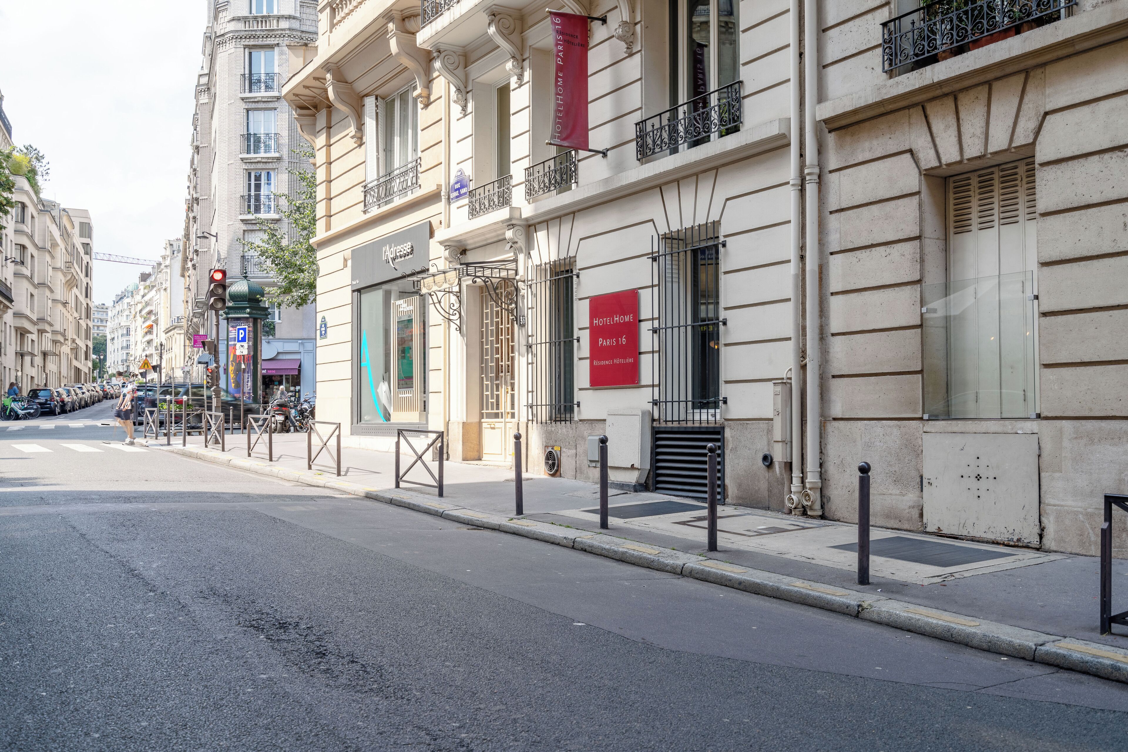 A street view of a building with a red sign indicating it is a hotel.