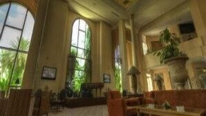 A spacious room with large windows, a fireplace, and a ceiling with intricate designs. - Regency Tunis Hotel (La Marsa)