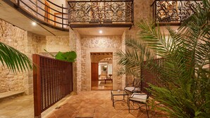A courtyard with stone walls, a wooden fence, and a seating area with chairs and a table. - Cas Comte Suites & Spa - Adults Only (Lloseta)