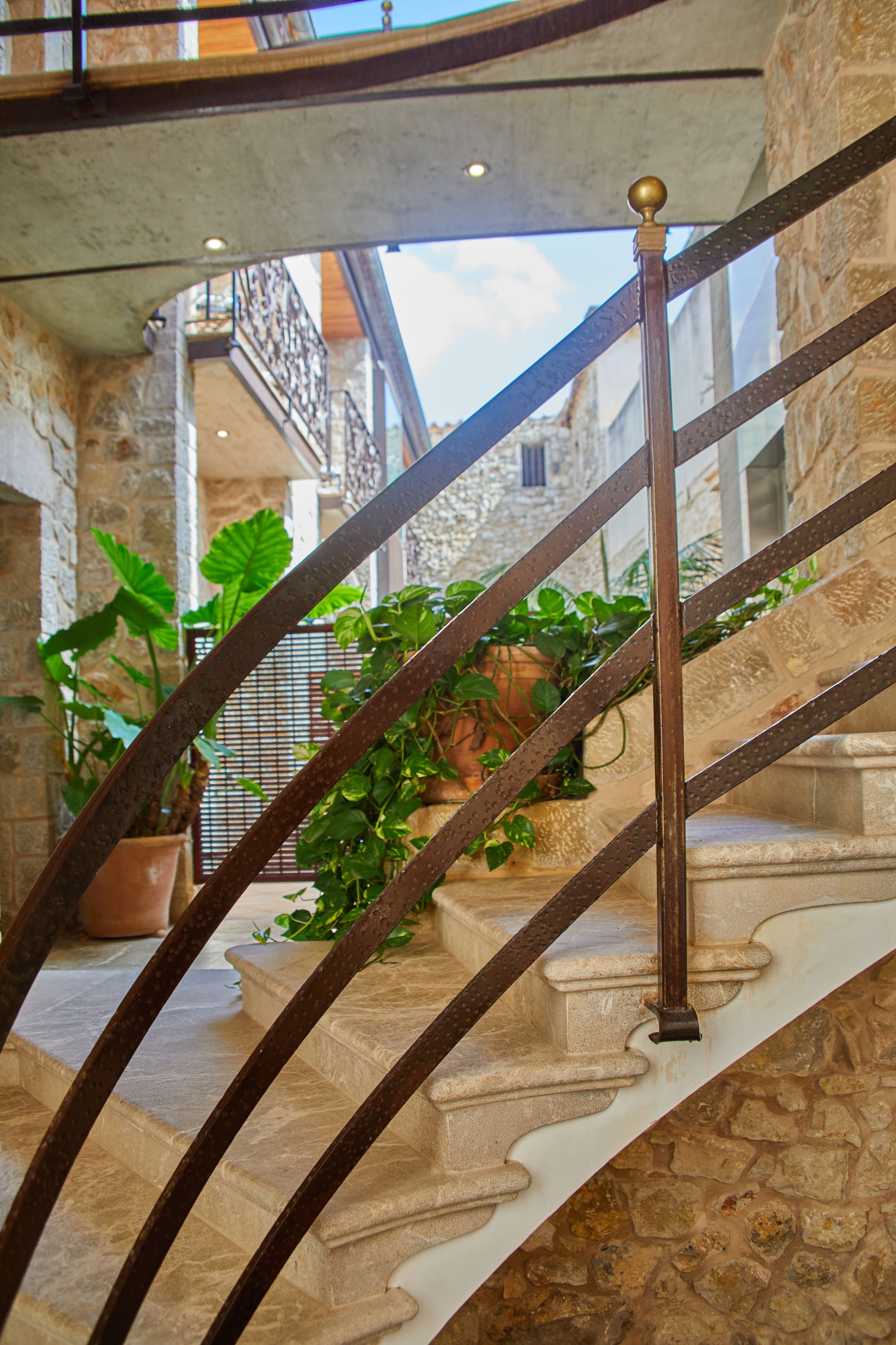 A stone staircase with metal railings and potted plants.