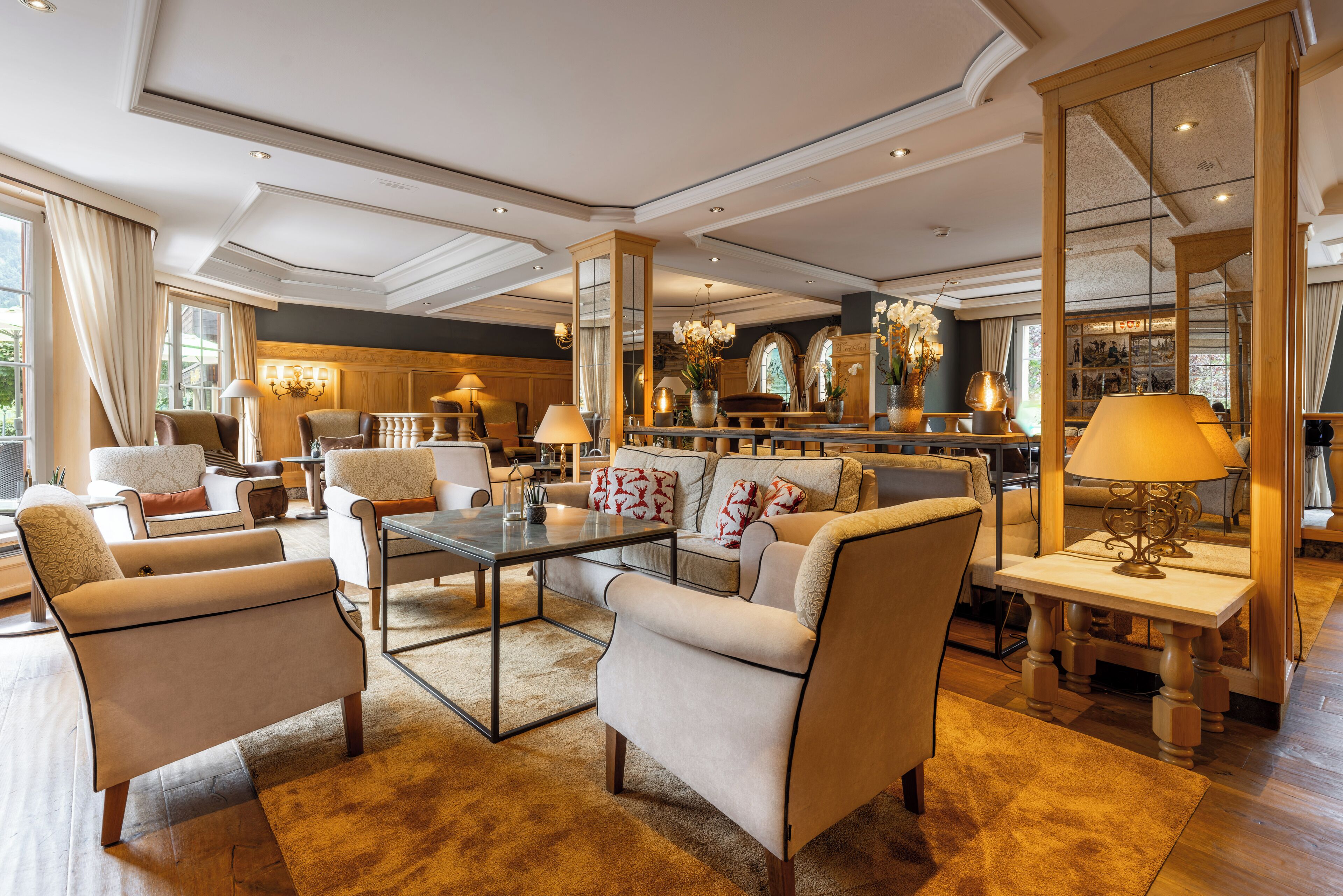 A spacious living room with a modern sofa set, a coffee table, and a decorative mirror.