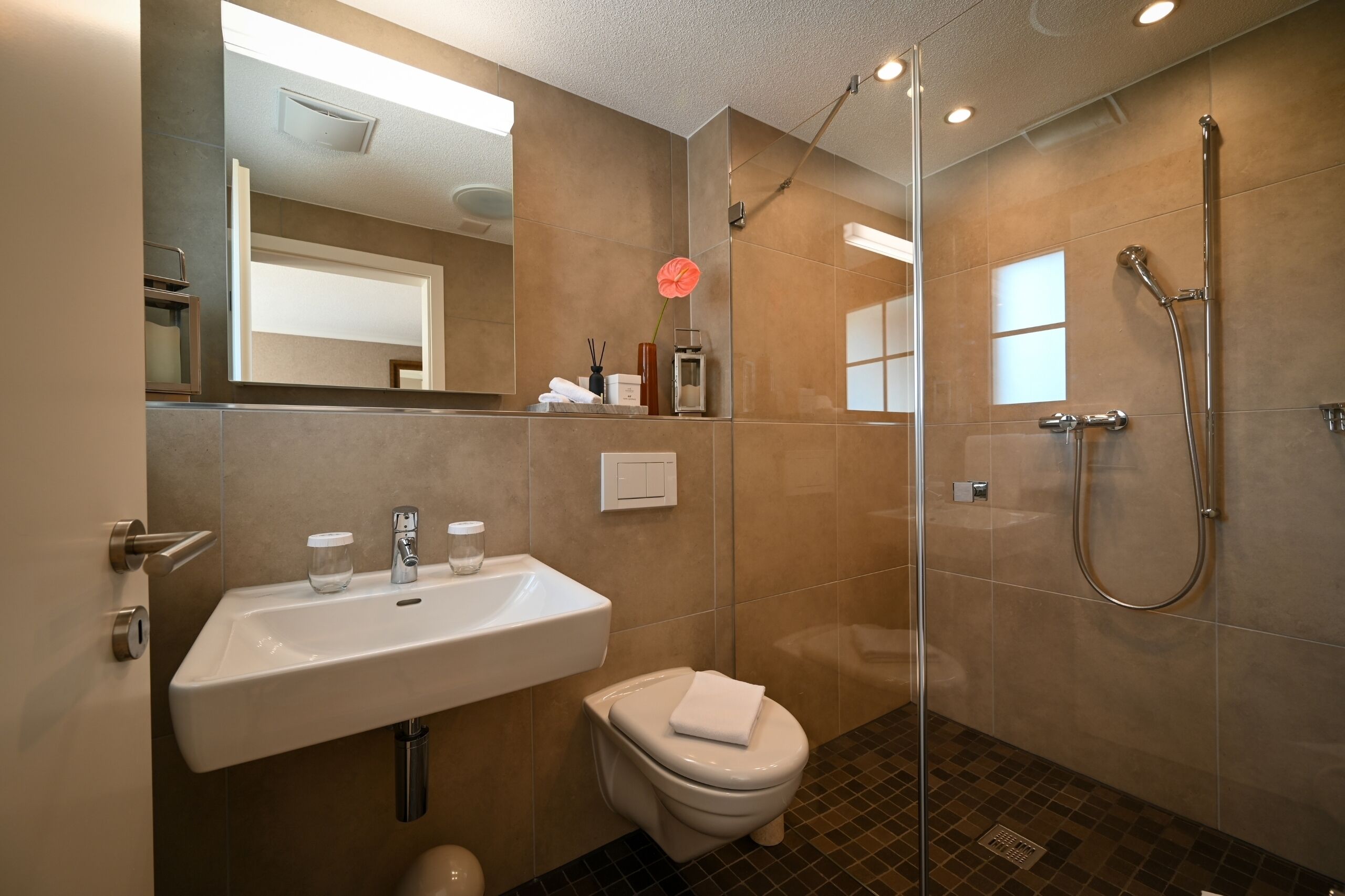 A modern bathroom with a sink, toilet, and shower.