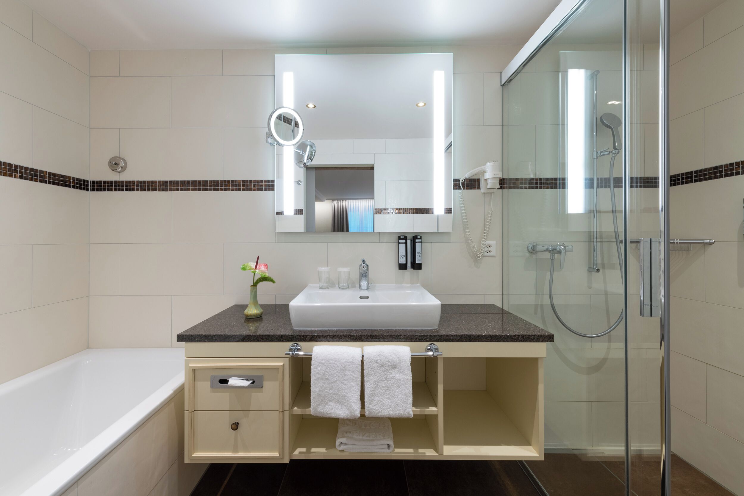 Un baño moderno con un lavamanos amplio, un espejo y una ducha.