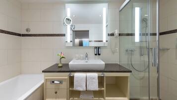 Un baño moderno con un lavamanos amplio, un espejo y una ducha.