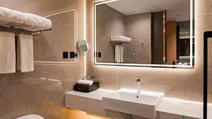 A modern bathroom with a large mirror, two sinks, and a towel rack. - Mingxing Conifer Hotel (Suining)