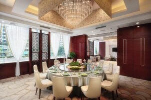 A dining room with a round table, chairs, and a chandelier.