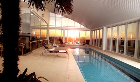 Una piscina techada, sillones reclinables de piscina