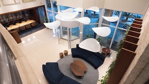 A modern lobby with a round seating area, a dining table, and a staircase. - Blue Tree Towers Caxias do Sul (Caxias do Sul)