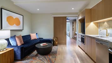 A modern living room with a blue sofa, a round coffee table, and a rug.