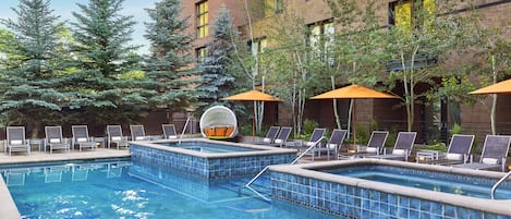 Una piscina al aire libre, sombrillas