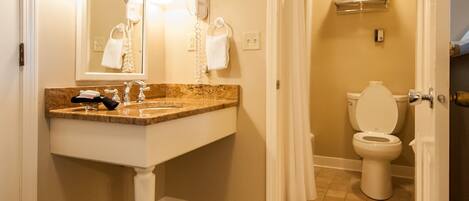 A bathroom with a sink, mirror, and toilet.