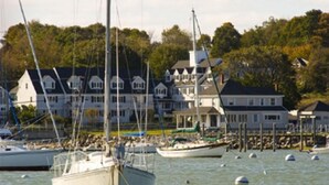 A marina with several boats docked, surrounded by residential buildings with a waterfront view. - The Inn At Scituate Harbor (Scituate)