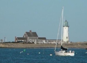 A lighthouse and a house by the water.