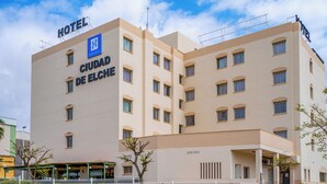 A hotel named "HOTEL CIUDAD DE ELCH" with a modern architectural design, multiple floors, and a clear sky in the background. - Hotel YIT Ciudad de Elche (Elche)