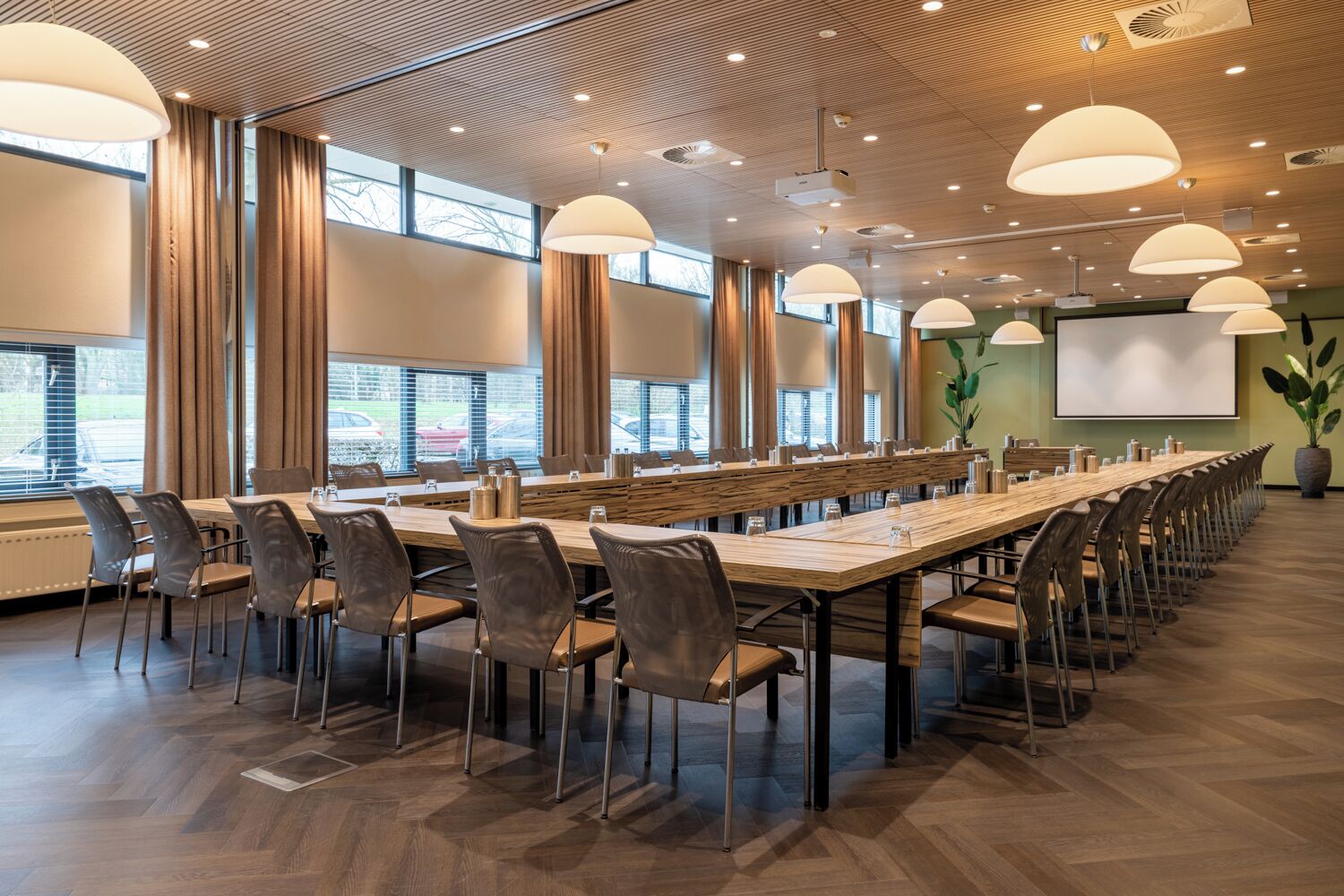 A conference room with a long table, chairs, and large windows.