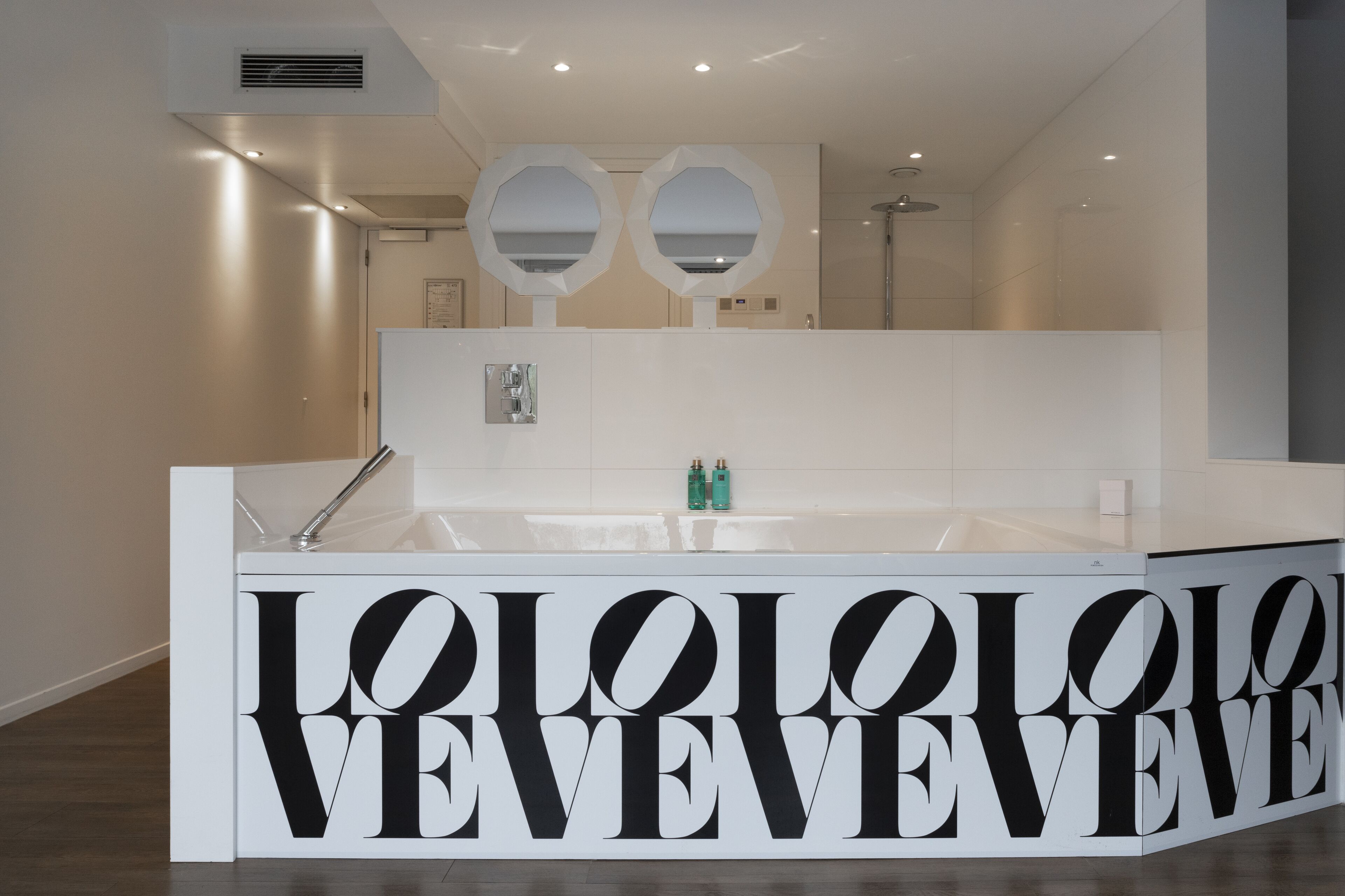 Une salle de bain moderne avec un grand miroir, un lavabo et un meuble-lavabo.